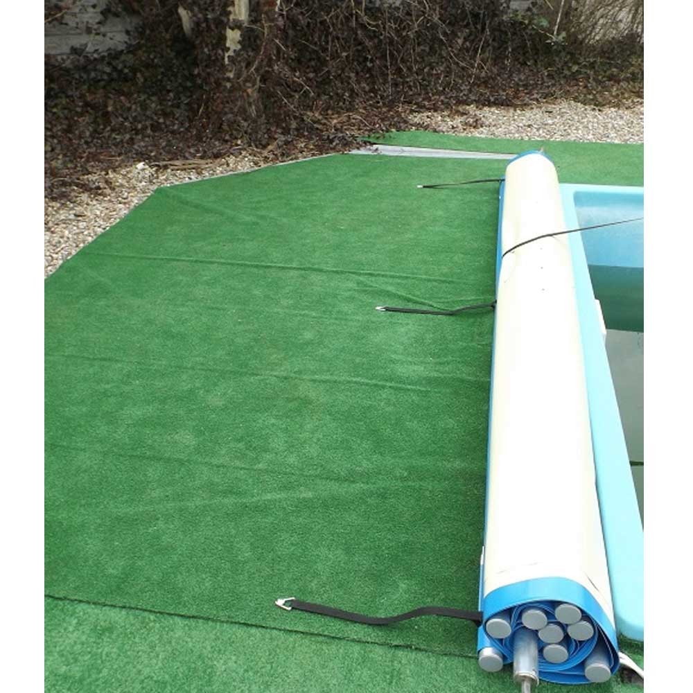 Das Bild zeigt eine aufgerollte grüne Sicherheits-Poolabdeckung mit schwarzen Bändern und dem seitlich sichtbaren Pool.