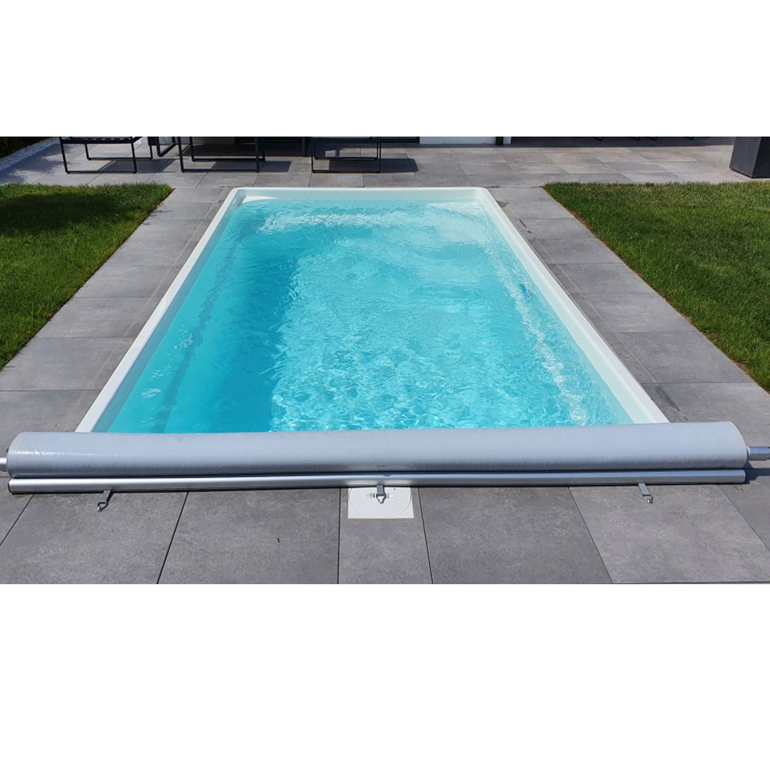 Rechteckiger Swimmingpool, teilweise überdacht durch einen Rollmechanismus auf einer grau gefliesten Oberfläche.