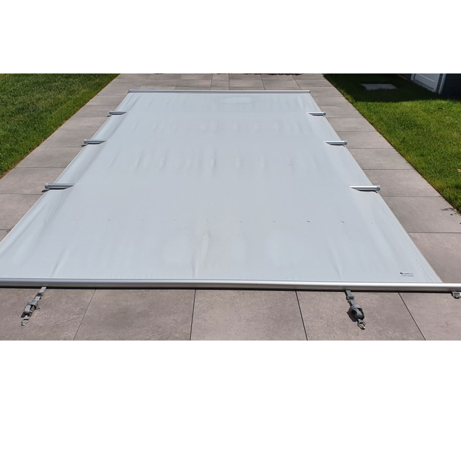Das Bild zeigt eine graue rechteckige Sicherheits-Poolabdeckung mit Metallstützen und Befestigungsmaterial.