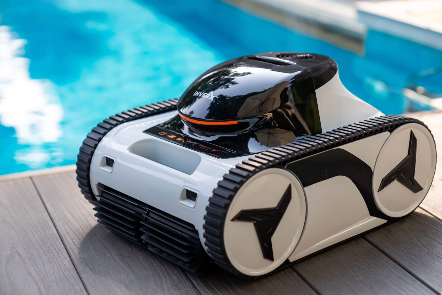 Pool-Reinigungsroboter mit Raupenketten und im Hintergrund sichtbarem Pool zur automatisierten Wartung.