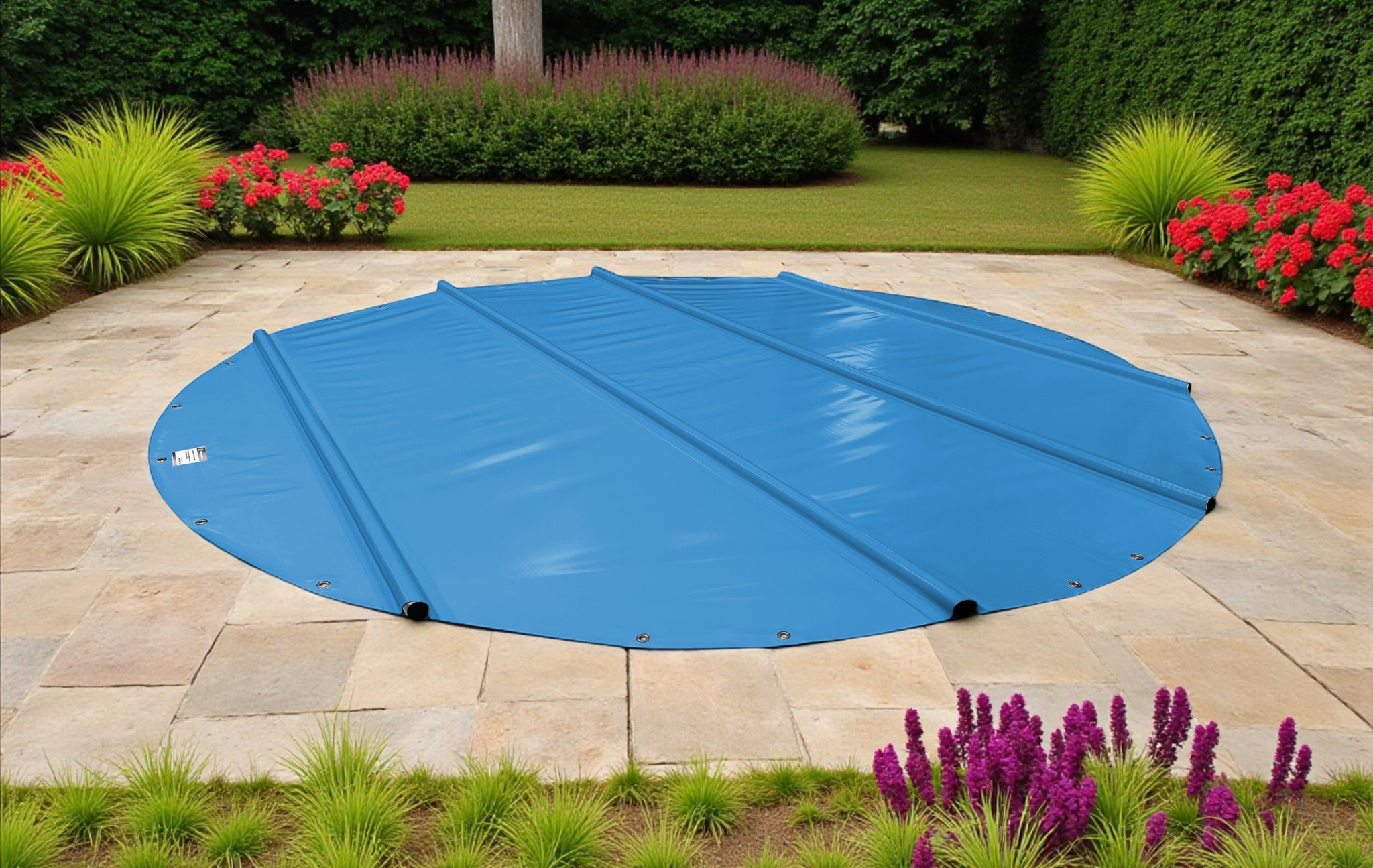 Ein blauer runder Pool ist mit einer blauen Sicherheitsabdeckung abgedeckt. Der Pool ist von einer Steinterrasse umgeben.