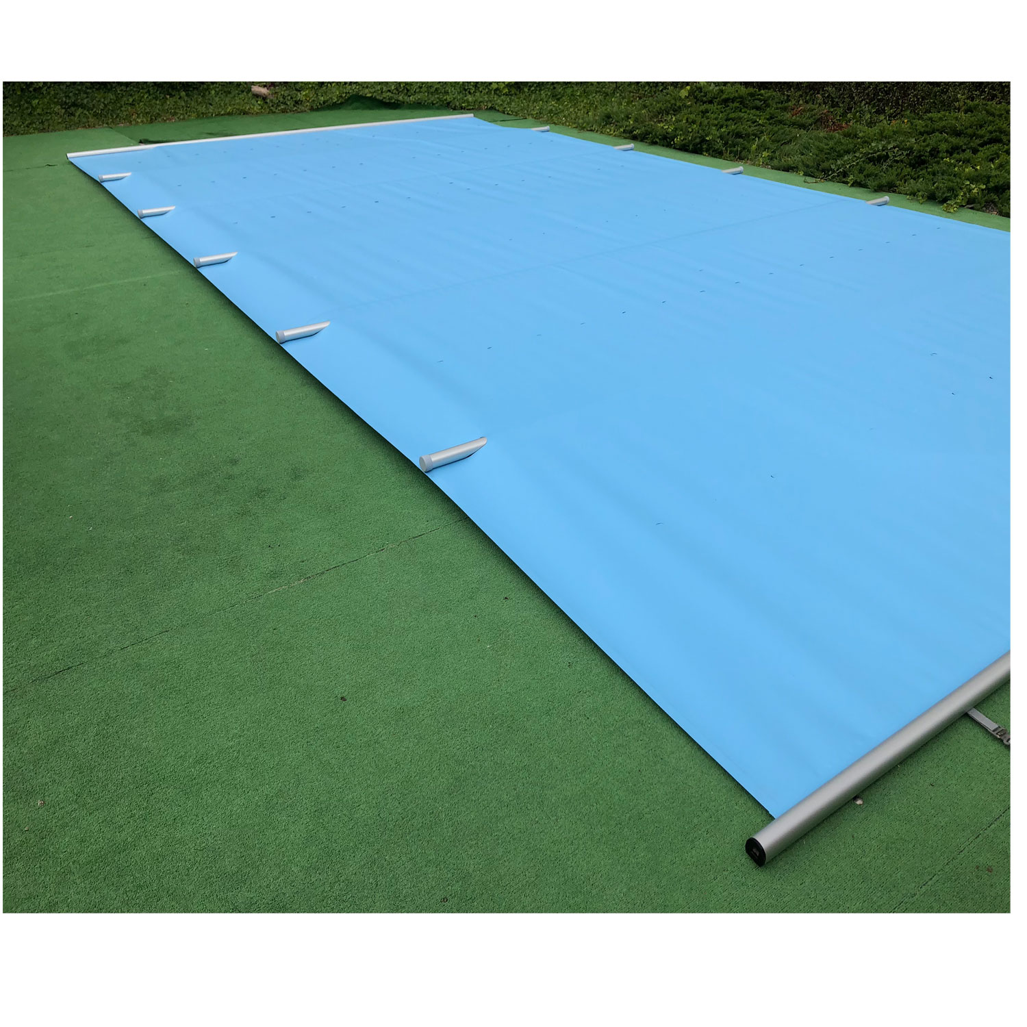 Rechteckiges Schwimmbecken mit blauer Sicherheitsabdeckung und Verankerungssystem.